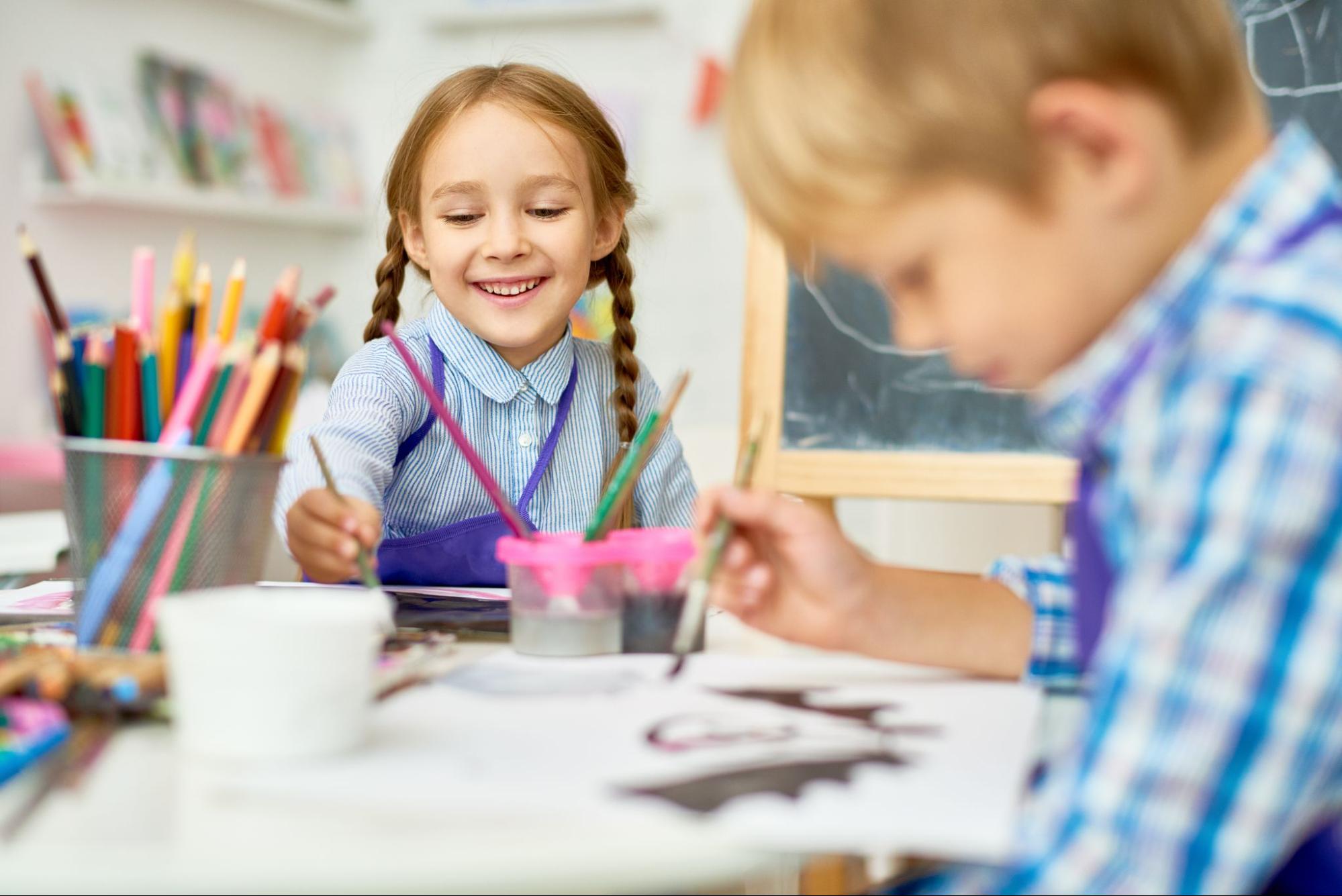 Children Art School. Двое детей улыбаются и рисуют. Child at School Painting. Дети радостные в творческой мастерской рисуют.